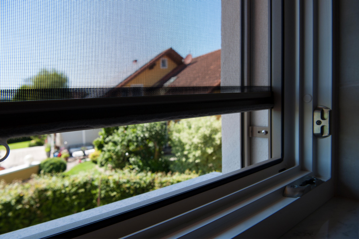 Fenster mit Insektenschutzrollo davor - halb offen